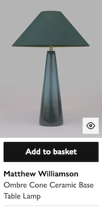 A card component for a lamp, the card contains an image underneath which is an Add to basket button. After the button is the product name.
